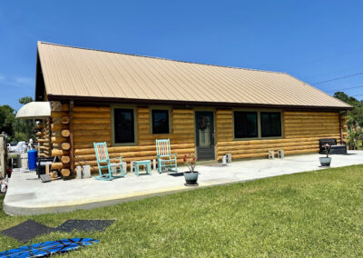 Image of log home with tan standing seam metal roof by Tri County Metals