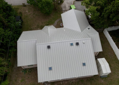 Metal roof installation feauring skylights and attic ventallation fan system.